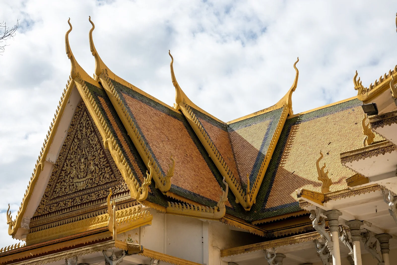 Ornate golden tiered roof with naga finials on the Throne Hall of the Royal Palace in Phnom Penh.