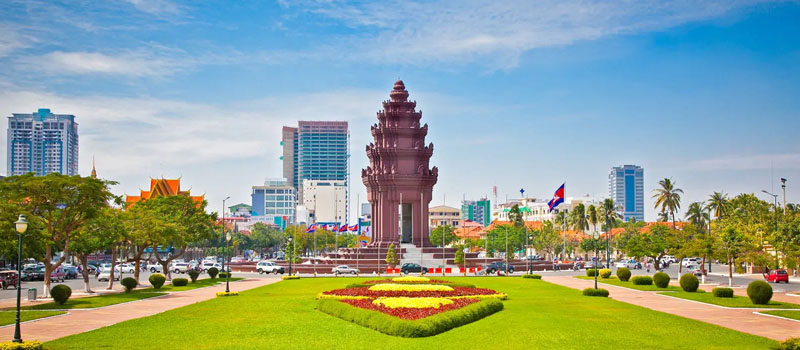 Traffic passing the red sandstone Independence Monument in central Phnom Penh