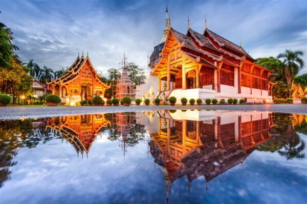 A Lanna temple hall mirrored in still water in Chiang Mai