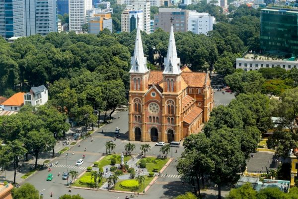 The brick towers of Notre-Dame Cathedral rising above the trees in central Ho Chi Minh City